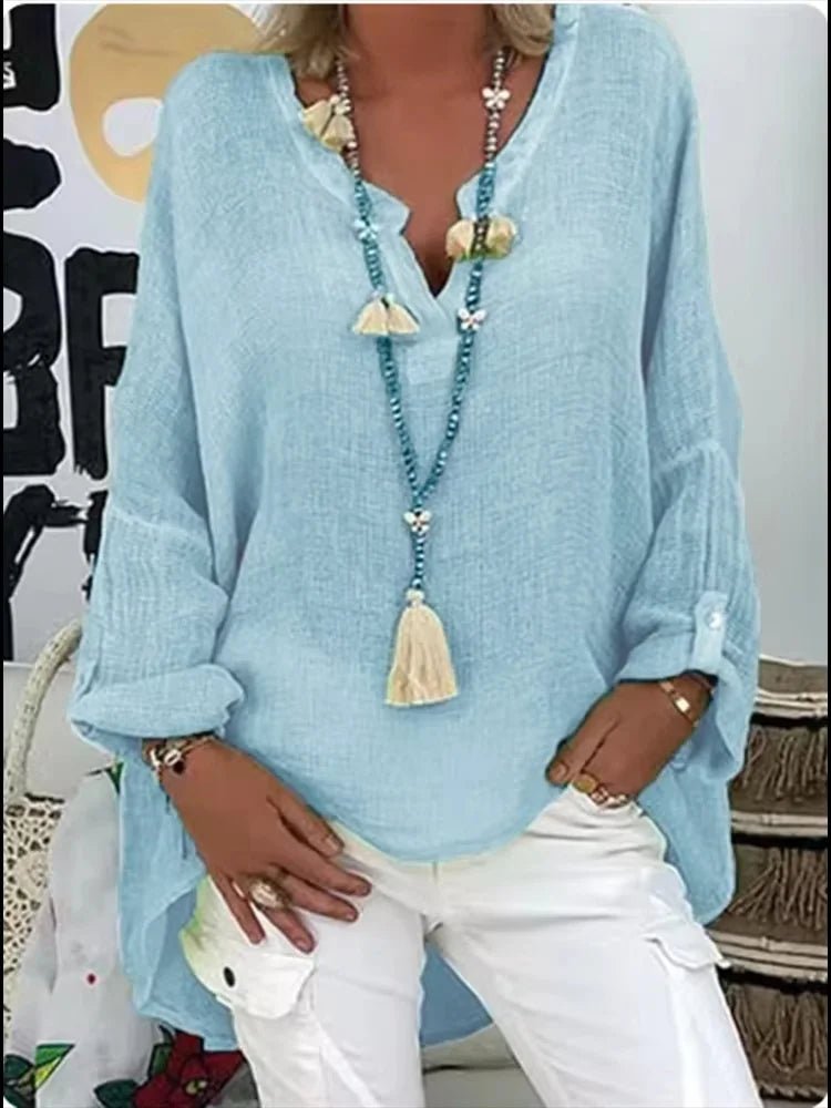 Plus size women’s blouse with V-neckline, roll-tab sleeves, relaxed fit, and curved hem, suitable for work, travel, and everyday wear.