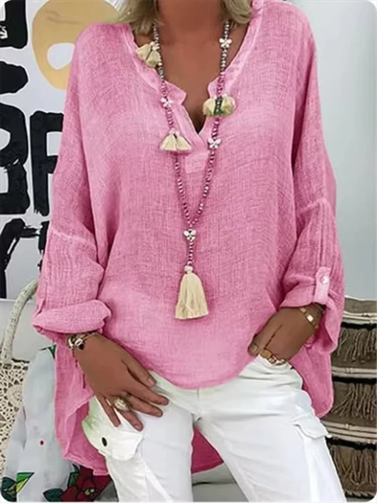 Plus size women’s blouse with V-neckline, roll-tab sleeves, relaxed fit, and curved hem, suitable for work, travel, and everyday wear.