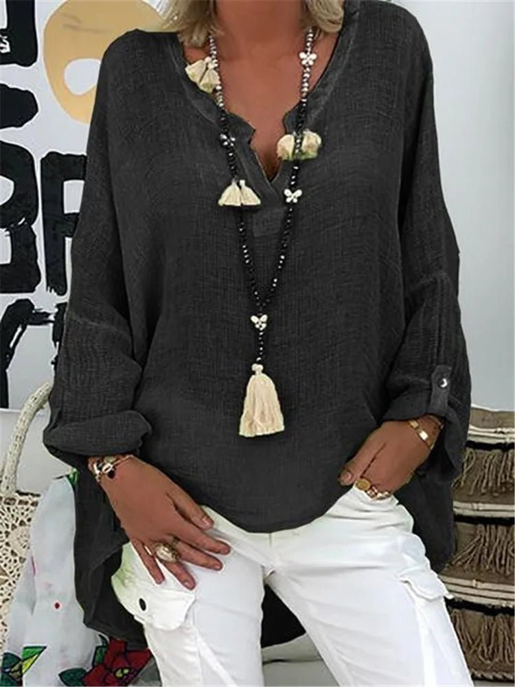 Plus size women’s blouse with V-neckline, roll-tab sleeves, relaxed fit, and curved hem, suitable for work, travel, and everyday wear.