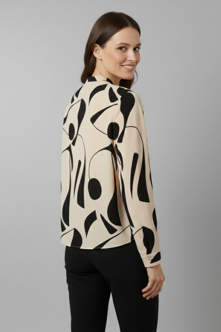 Women’s collared blouse with button front and abstract print, featuring long sleeves and a curved hem for everyday and work styling.