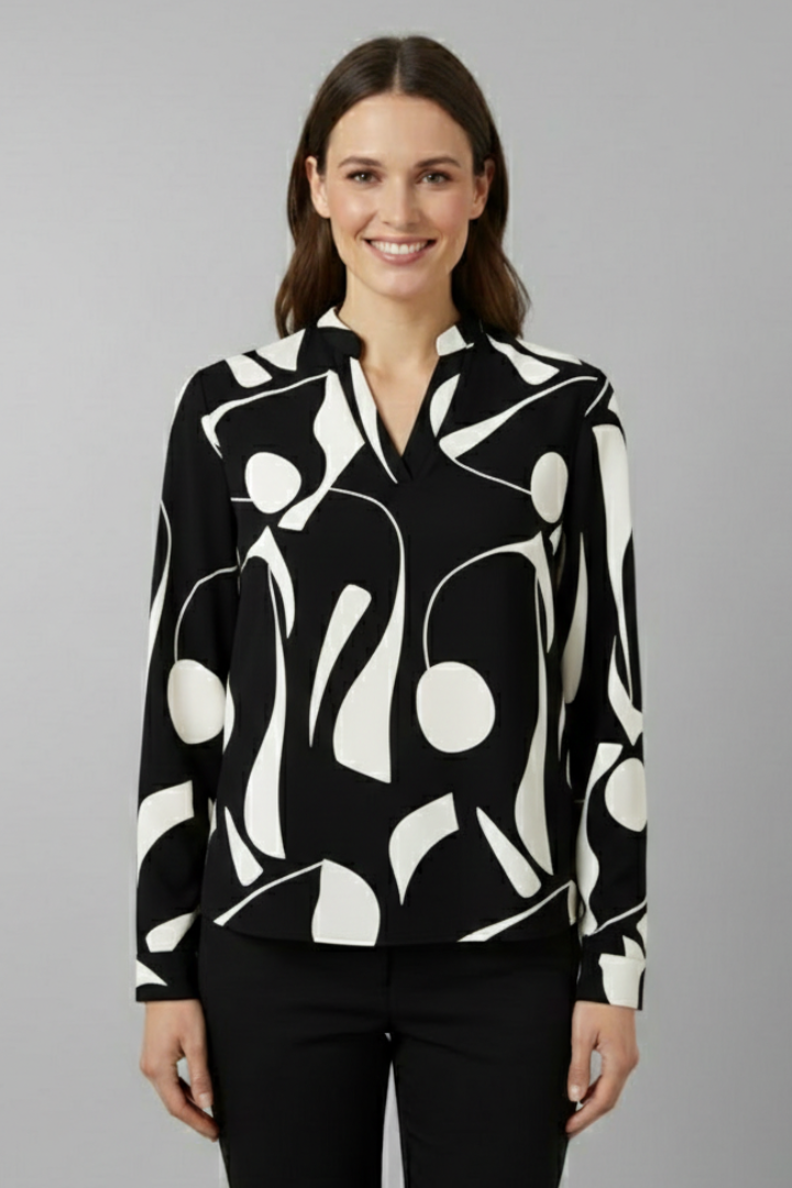 Women’s collared blouse with button front and abstract print, featuring long sleeves and a curved hem for everyday and work styling.