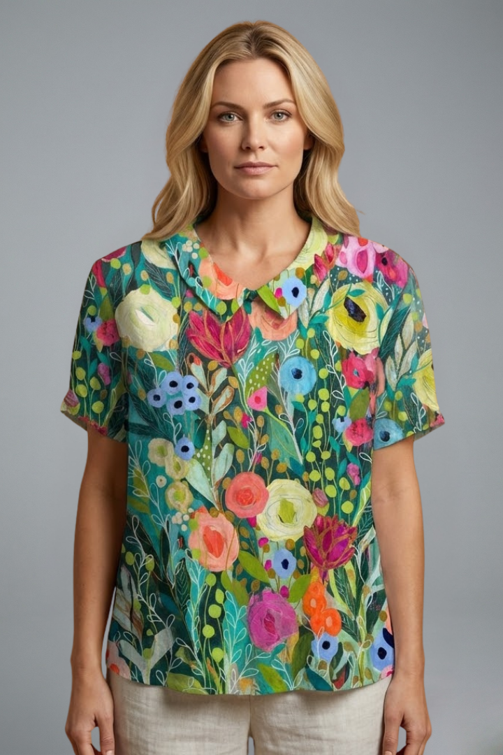 Women’s floral blouse with round neckline, short sleeves, relaxed fit, and straight hem for casual everyday styling.
