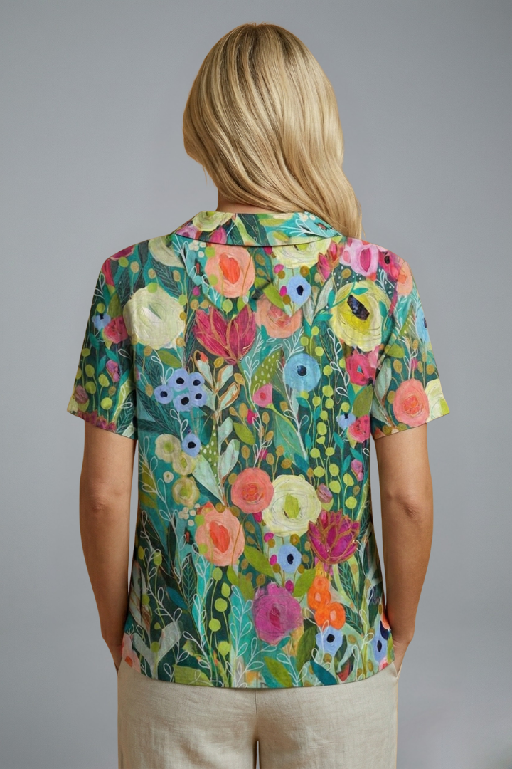 Women’s floral blouse with round neckline, short sleeves, relaxed fit, and straight hem for casual everyday styling.