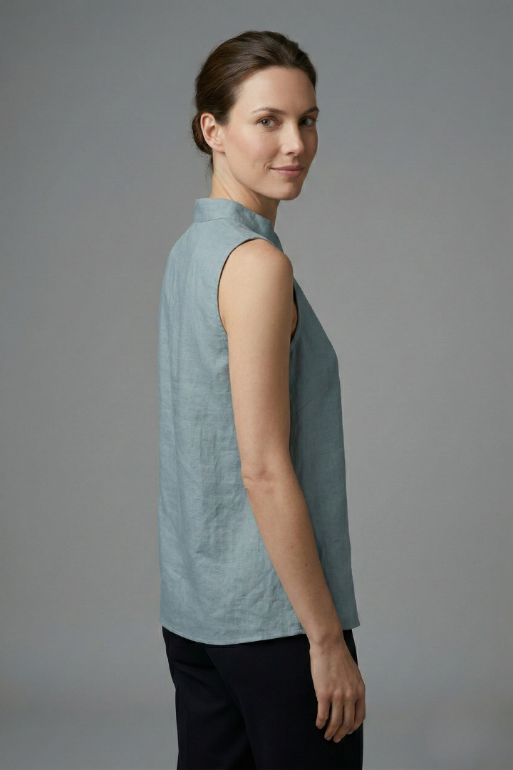 Women’s sleeveless blouse with high neckline, button placket, and structured shoulders, suitable for office wear and casual outfits.