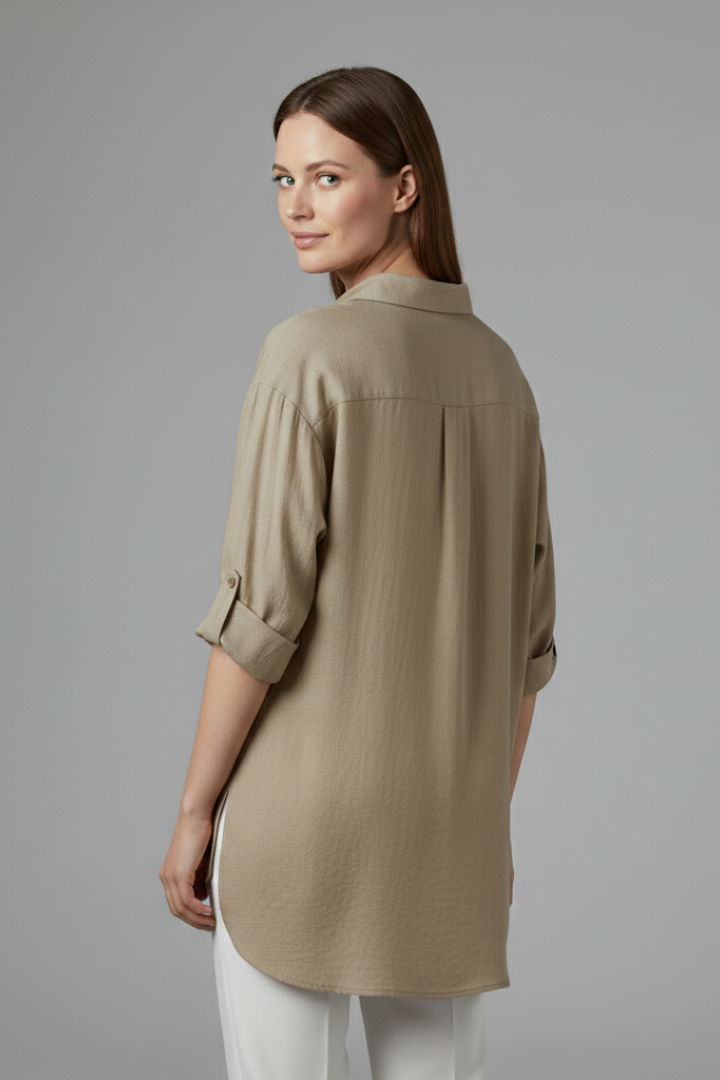 Women’s long blouse with button fastening and chest pockets, featuring a collared neckline and rounded hem for everyday and work styling.