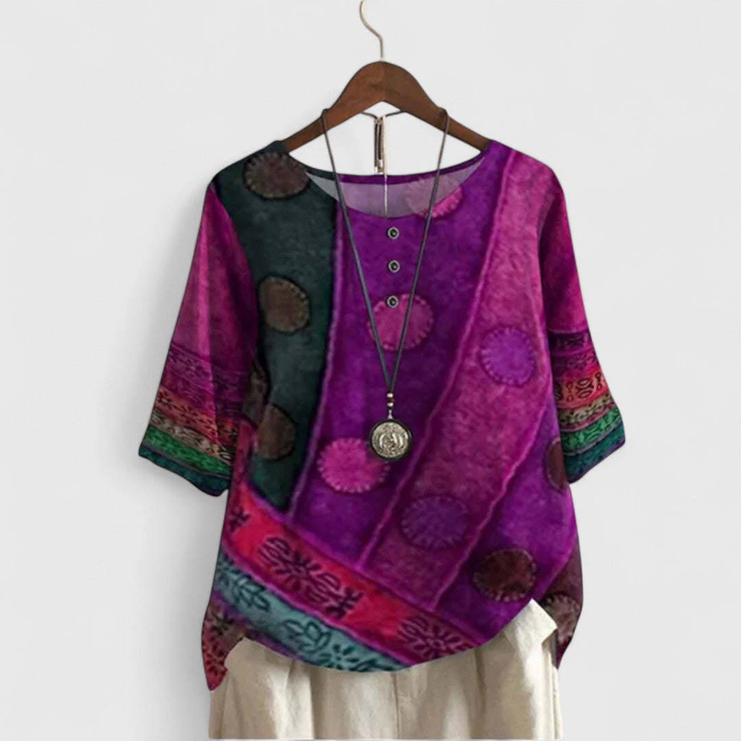 Women’s printed top with a patchwork-inspired design, decorative buttons, and a relaxed fit, ideal for travel and everyday wear.