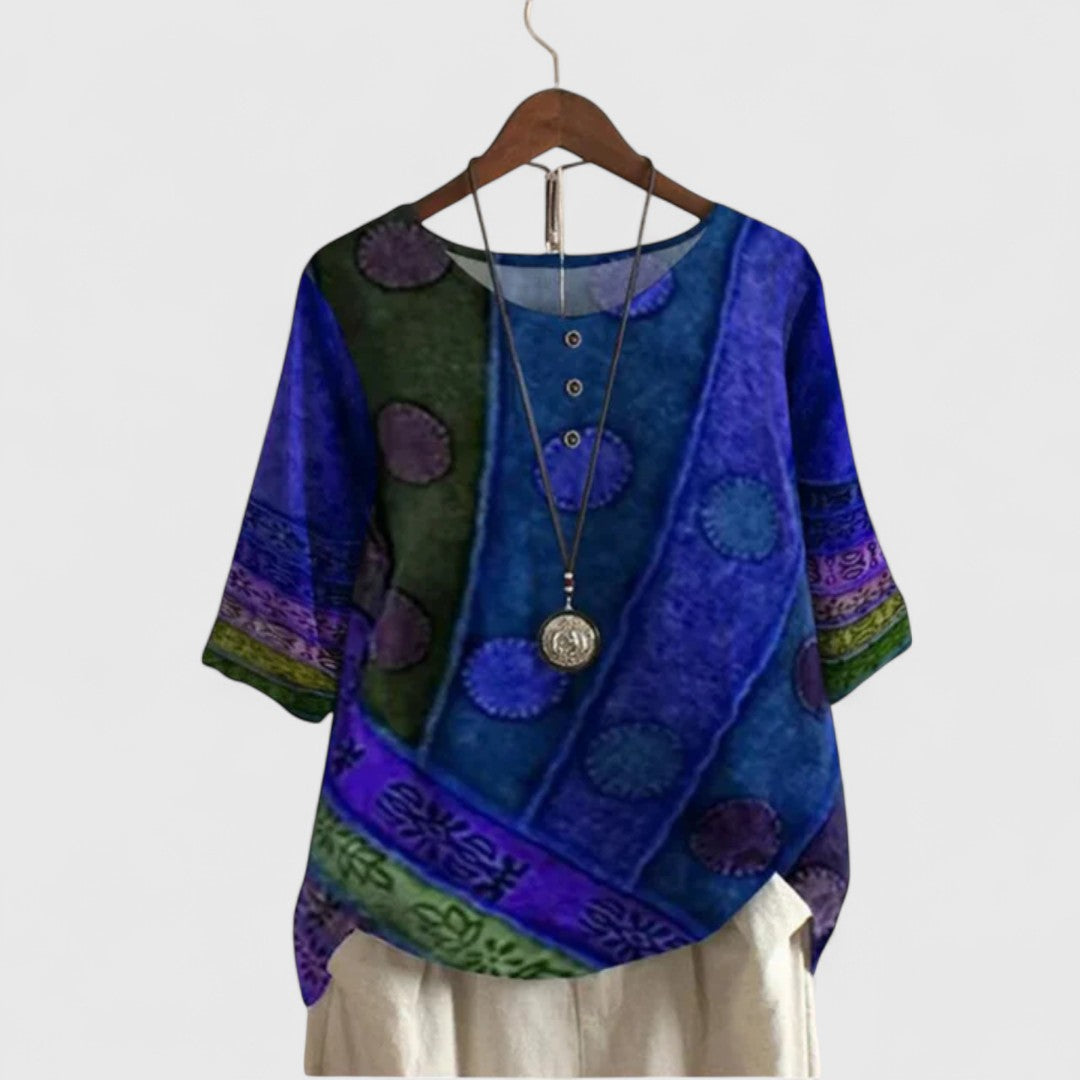 Women’s printed top with a patchwork-inspired design, decorative buttons, and a relaxed fit, ideal for travel and everyday wear.