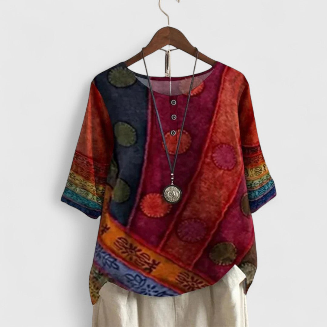 Women’s printed top with a patchwork-inspired design, decorative buttons, and a relaxed fit, ideal for travel and everyday wear.