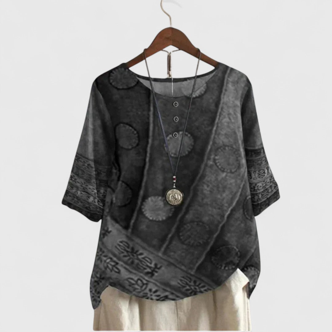 Women’s printed top with a patchwork-inspired design, decorative buttons, and a relaxed fit, ideal for travel and everyday wear.