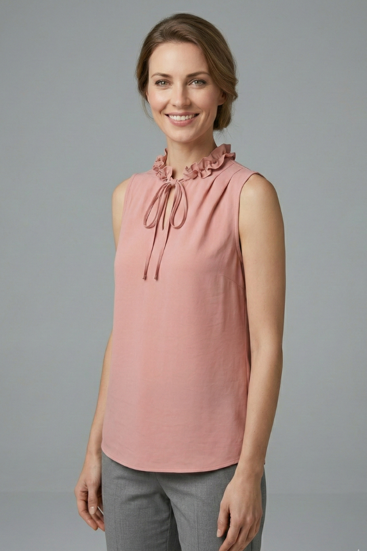 Women’s sleeveless top with ruffle V-neckline, button detail, and wide shoulders, suitable for casual wear and office outfits.