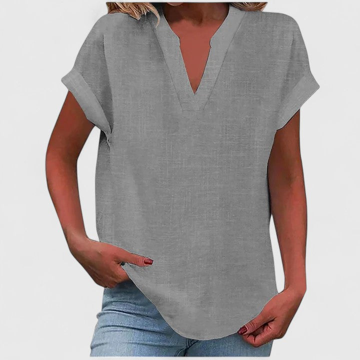 Women’s V-neck blouse with rolled short sleeves and relaxed fit, ideal for smart-casual outfits and everyday styling.