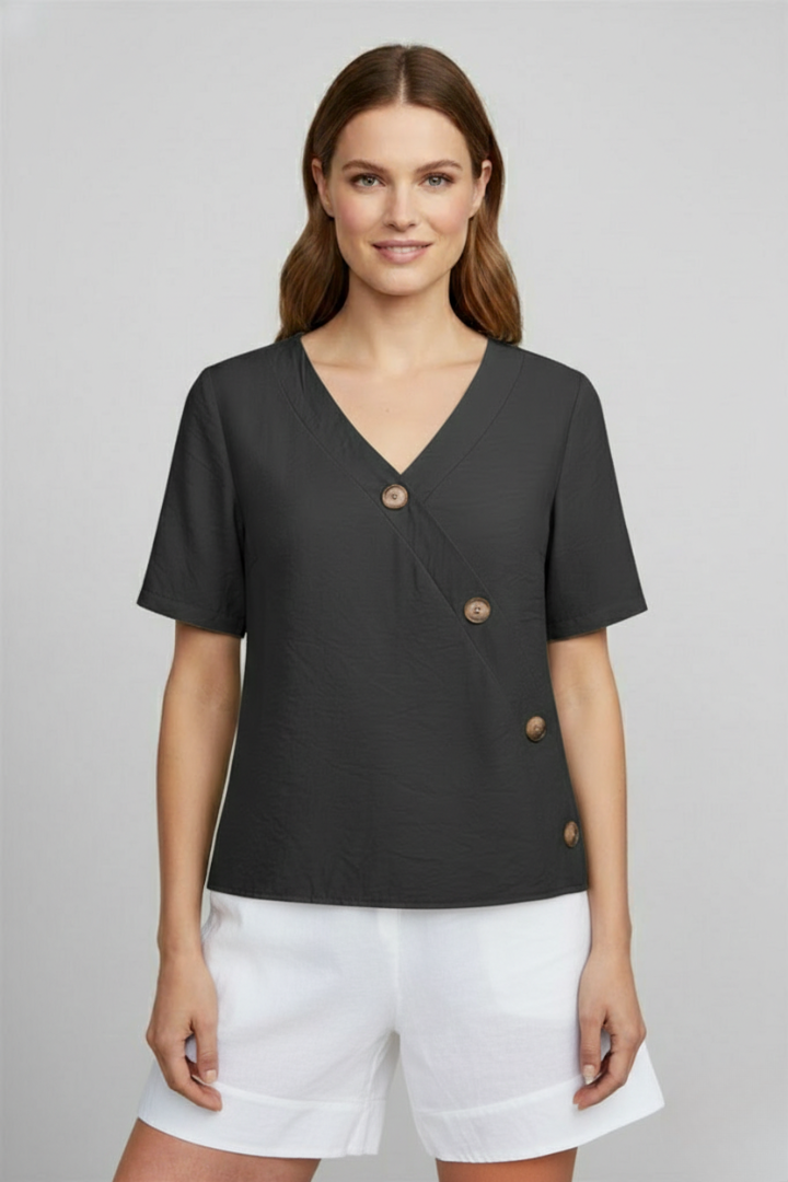 Women’s wrap style blouse with V-neckline and button accents, featuring short sleeves and a straight hem for office or everyday wear.