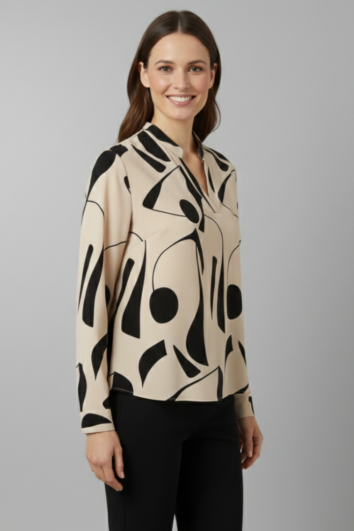 Women’s collared blouse with button front and abstract print, featuring long sleeves and a curved hem for everyday and work styling.