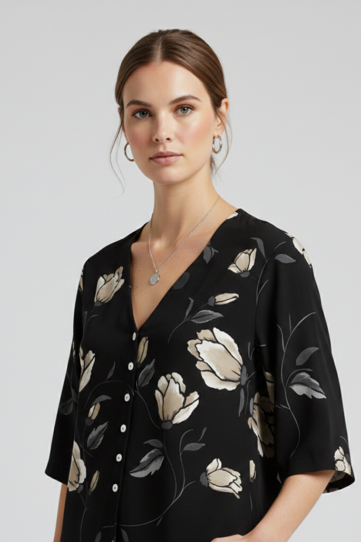 Women’s blouse with V-neckline and front button detailing, featuring short sleeves and floral print for everyday and casual styling.