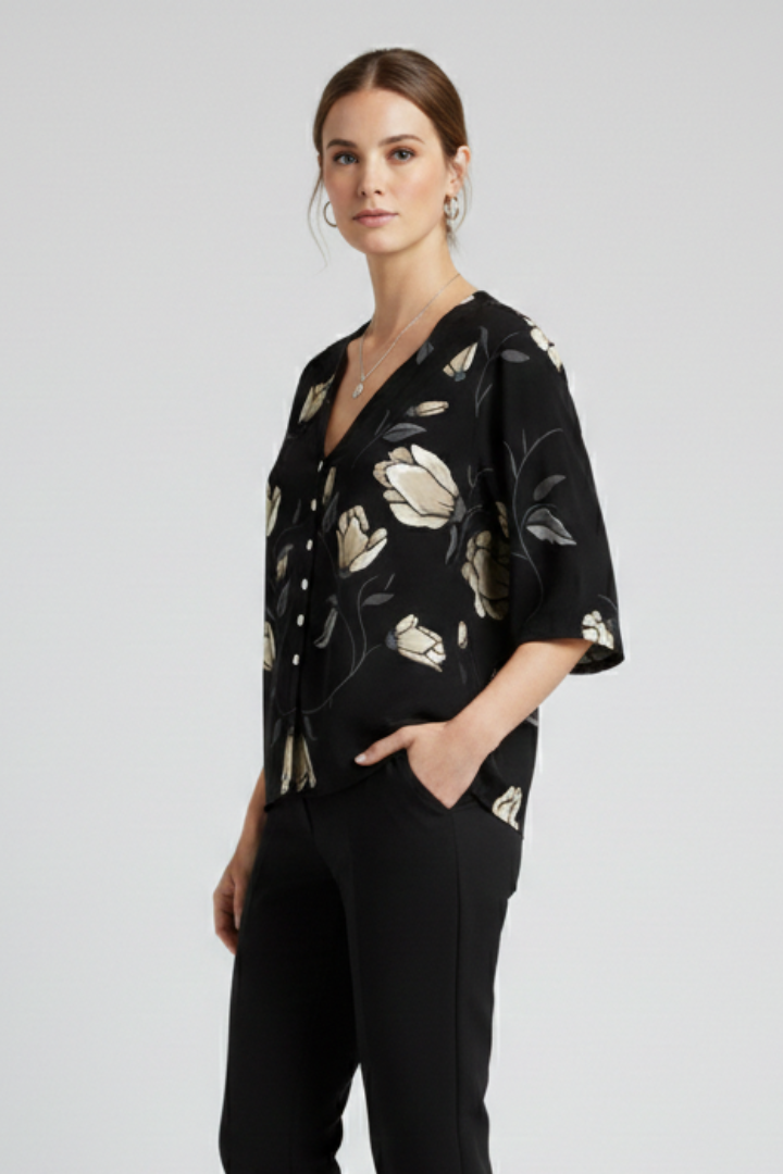 Women’s blouse with V-neckline and front button detailing, featuring short sleeves and floral print for everyday and casual styling.