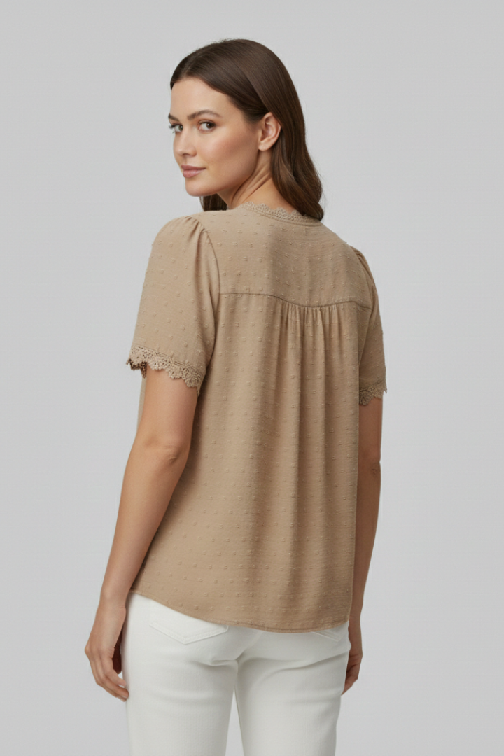 Women’s short sleeve blouse with V neckline, partial button fastening, and textured semi-sheer surface, suitable for office wear and everyday styling.