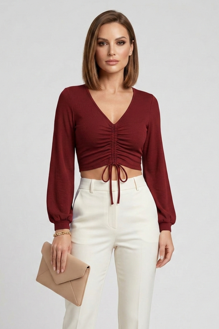 Women’s crop top with ruched front detail, v-neck, and long sleeves, ideal for casual evening outfits and party styling.