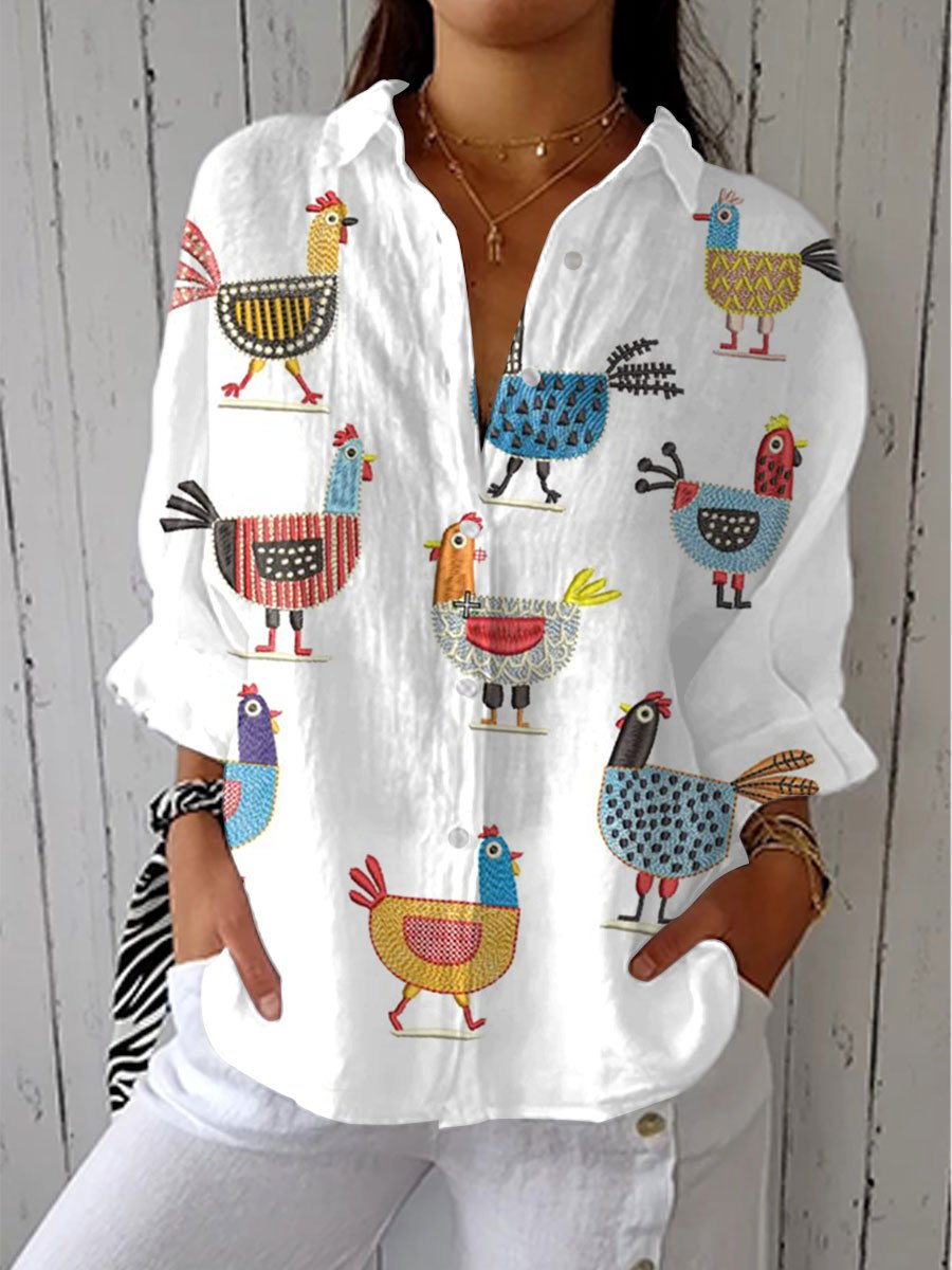 Women’s blouse with colorful hen print, button-front closure, V-neckline, and relaxed fit, suitable for casual outings and everyday styling.