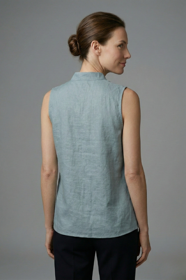 Women’s sleeveless blouse with high neckline, button placket, and structured shoulders, suitable for office wear and casual outfits.