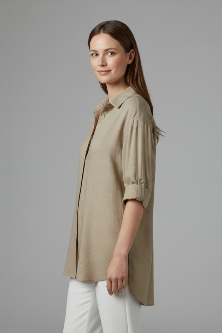 Women’s long blouse with button fastening and chest pockets, featuring a collared neckline and rounded hem for everyday and work styling.