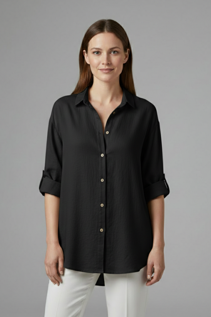Women’s long blouse with button fastening and chest pockets, featuring a collared neckline and rounded hem for everyday and work styling.
