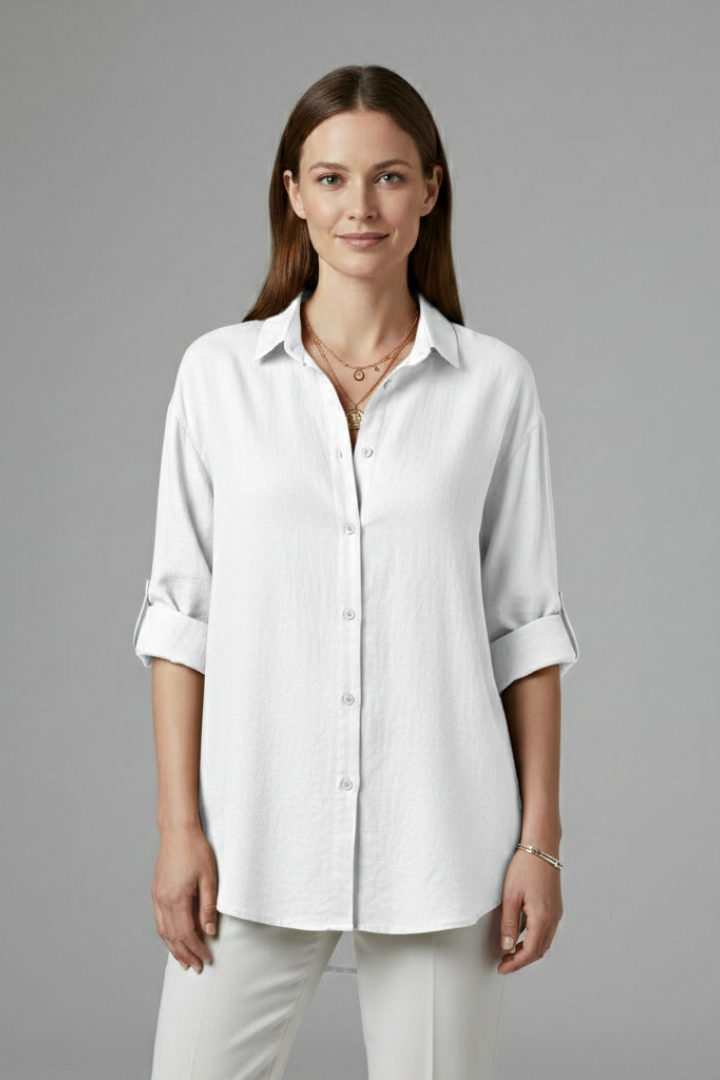 Women’s long blouse with button fastening and chest pockets, featuring a collared neckline and rounded hem for everyday and work styling.