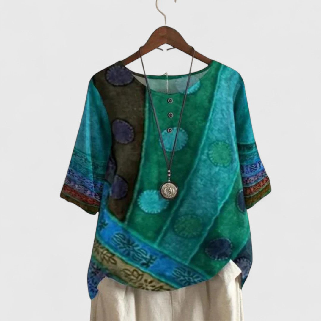 Women’s printed top with a patchwork-inspired design, decorative buttons, and a relaxed fit, ideal for travel and everyday wear.