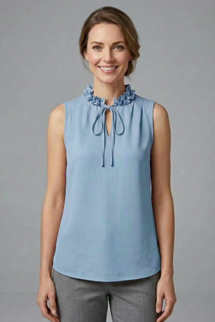 Women’s sleeveless top with ruffle V-neckline, button detail, and wide shoulders, suitable for casual wear and office outfits.
