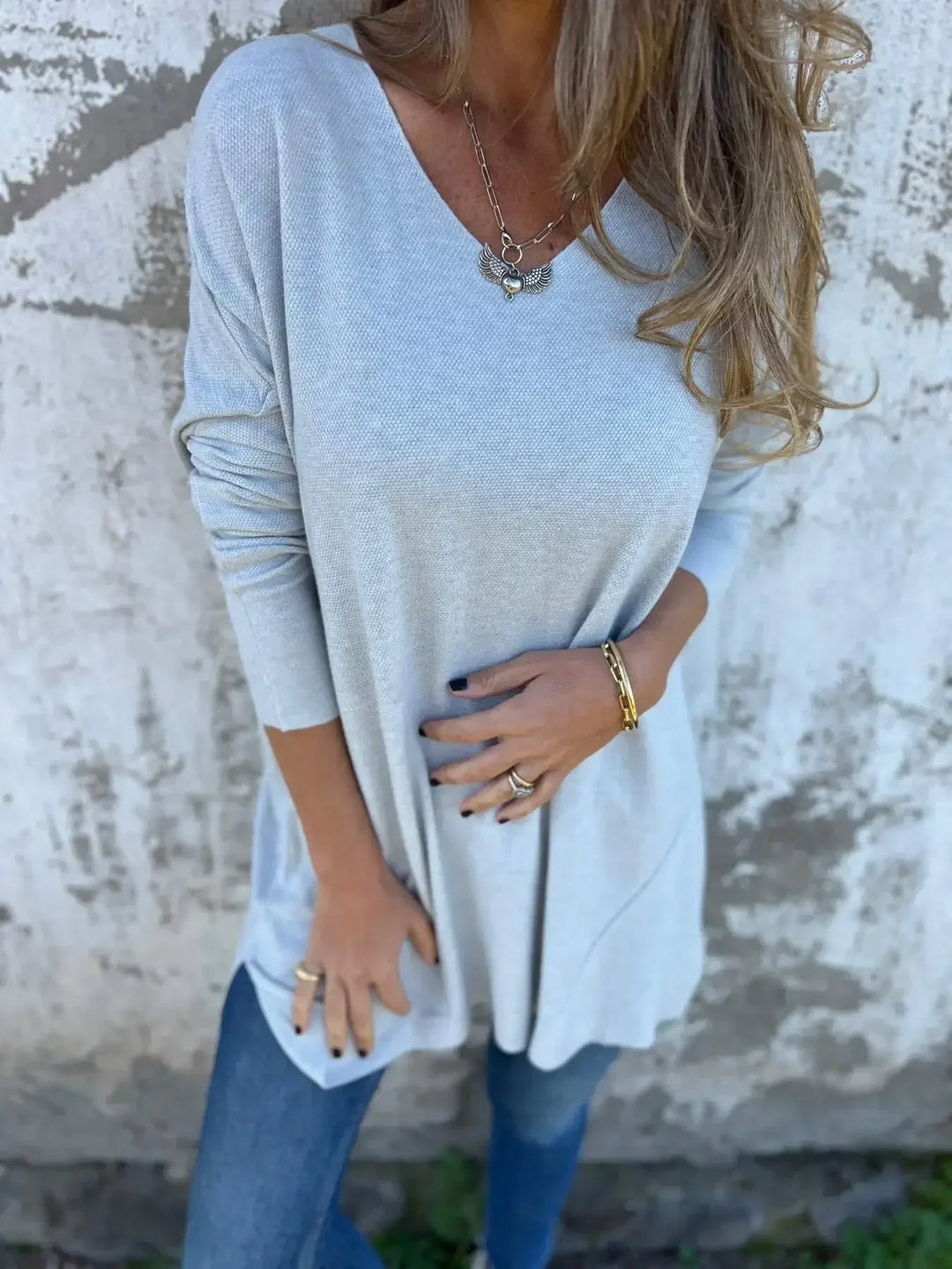 Women’s tunic top with V-neckline, longline length, and relaxed oversized fit, suitable for casual wear, layering, and everyday styling.