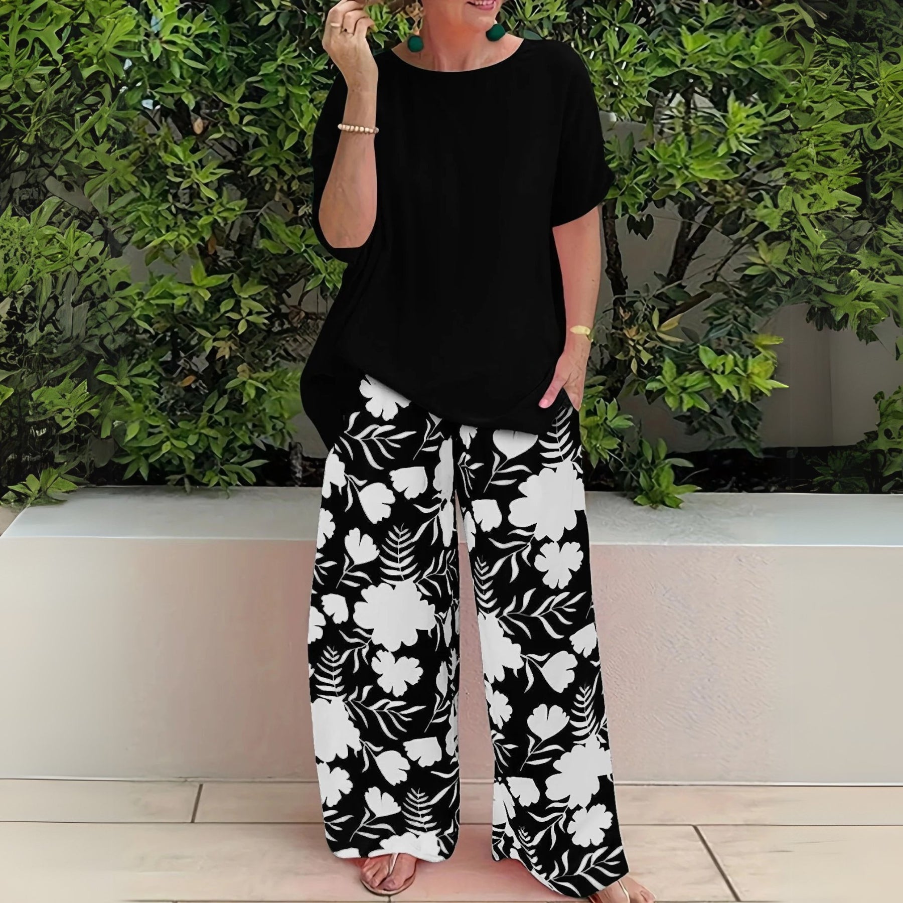 Women’s two-piece set featuring a relaxed-fit top and floral wide-leg pants, suitable for casual outings, travel, and everyday wear.