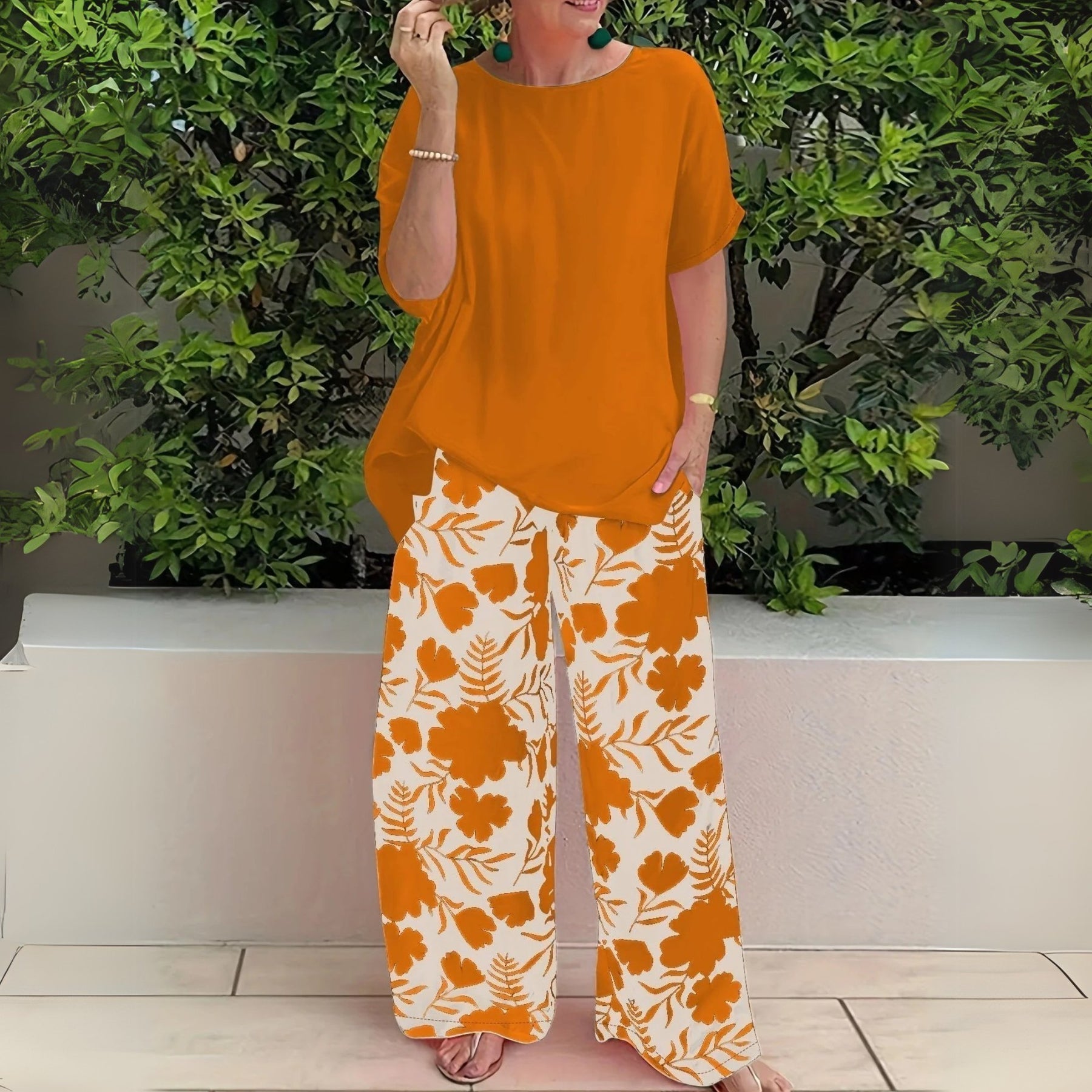 Women’s two-piece set featuring a relaxed-fit top and floral wide-leg pants, suitable for casual outings, travel, and everyday wear.