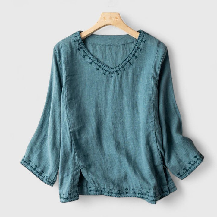 Women’s v-neck blouse with embroidered detailing and a relaxed fit, suitable for office outfits, casual wear, and smart occasions.