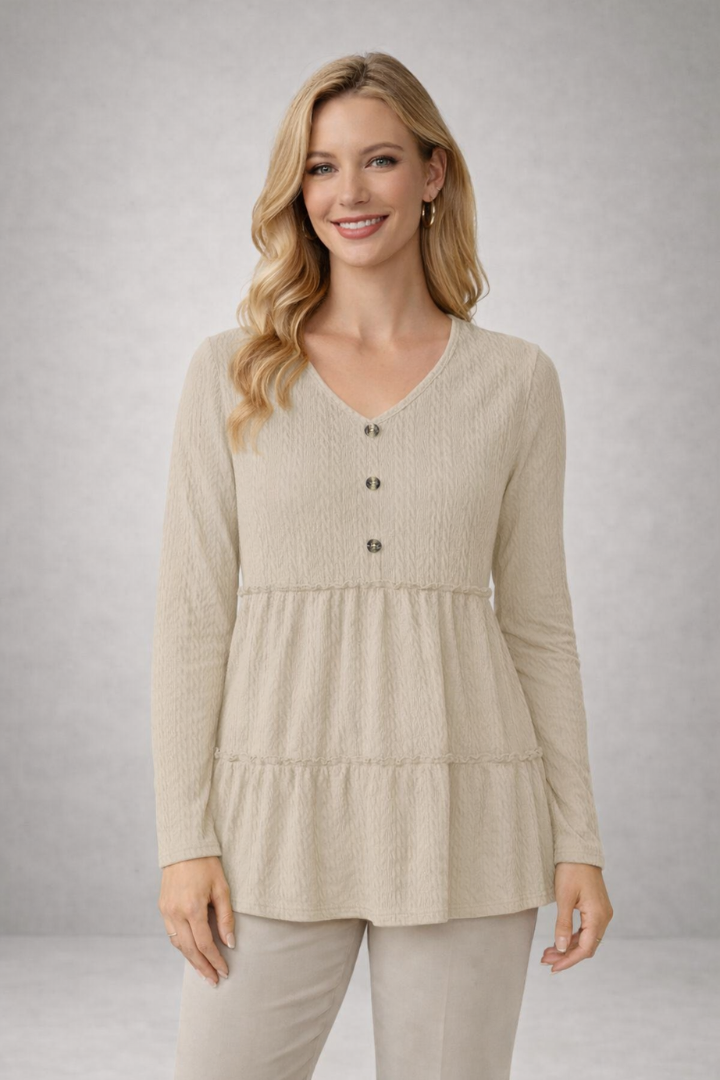 Women’s long sleeve top with v-neckline and tiered hem, featuring a textured surface for casual wear and office outfits