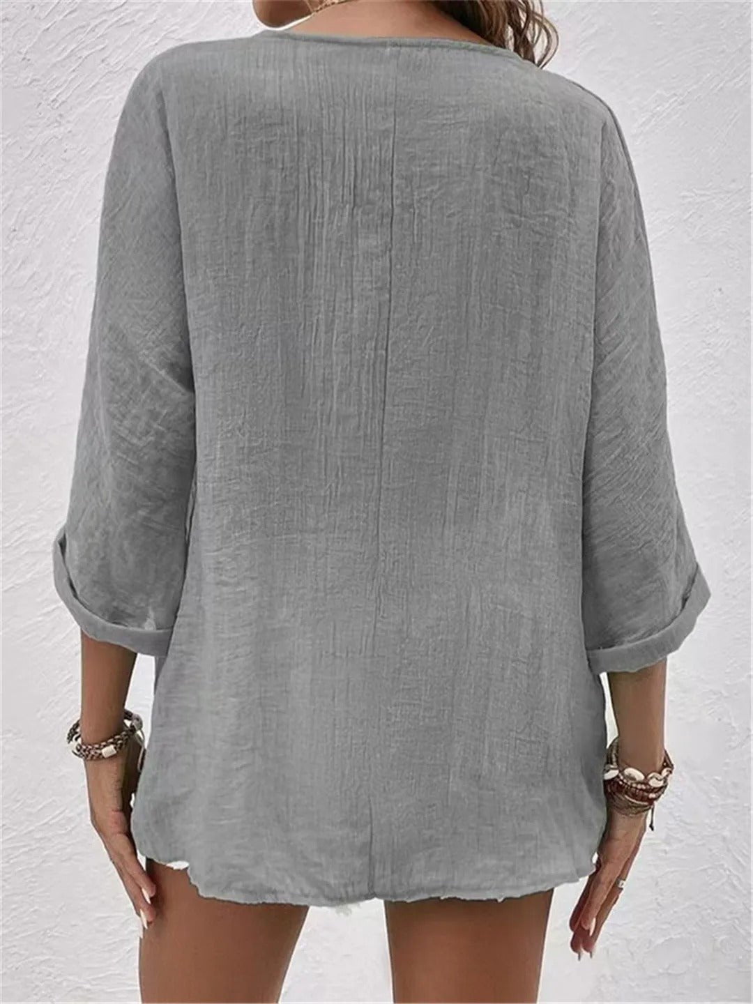 Women’s V-neck top with button-front closure and three-quarter sleeves, perfect for casual wear, travel, and warm-weather styling.