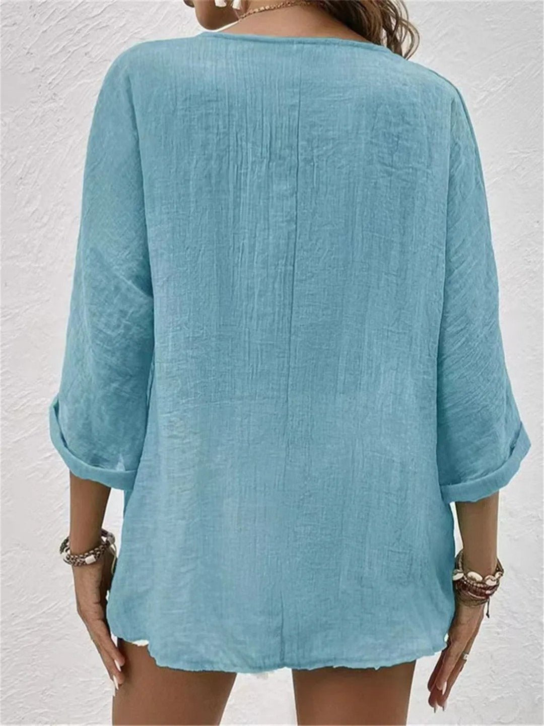 Women’s V-neck top with button-front closure and three-quarter sleeves, perfect for casual wear, travel, and warm-weather styling.