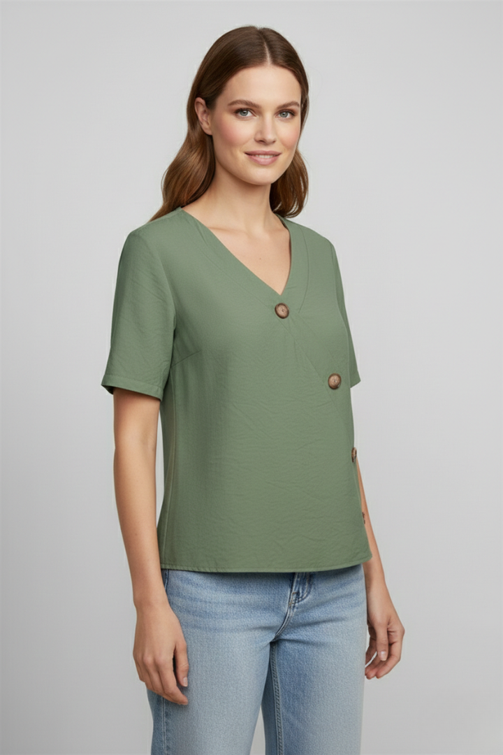 Women’s wrap style blouse with V-neckline and button accents, featuring short sleeves and a straight hem for office or everyday wear.