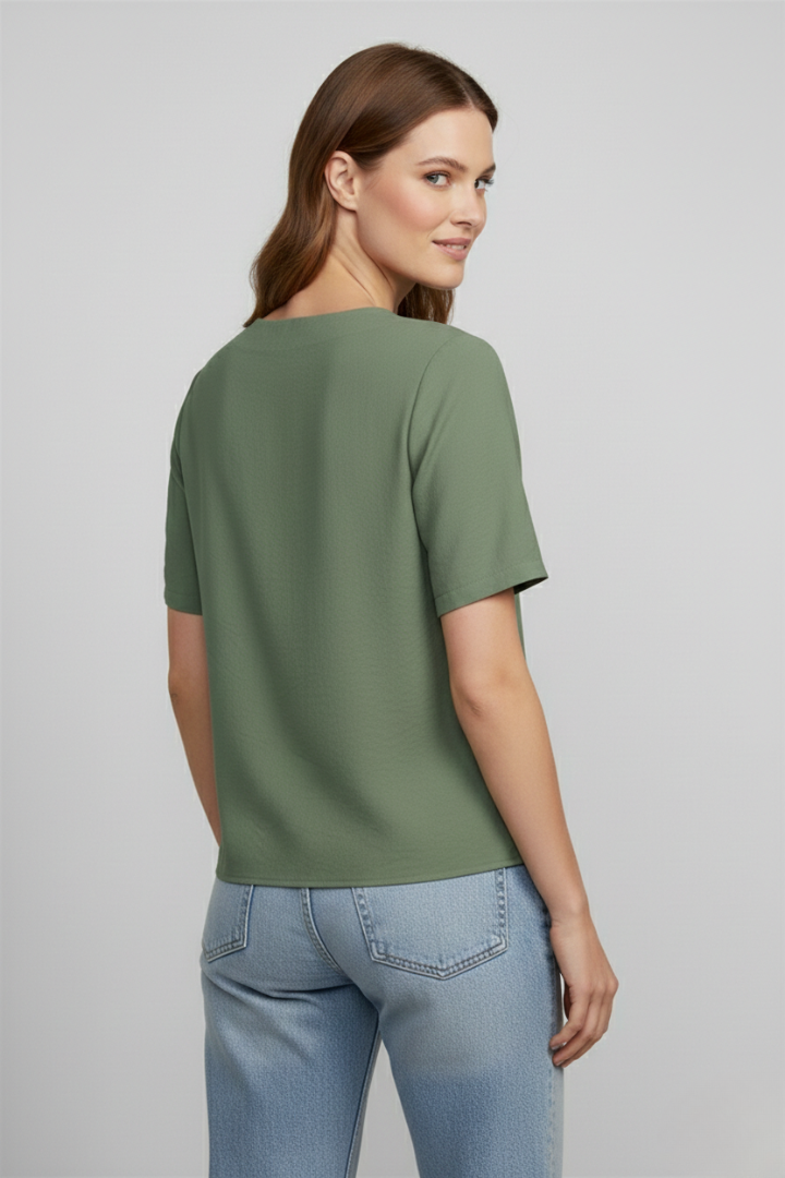 Women’s wrap style blouse with V-neckline and button accents, featuring short sleeves and a straight hem for office or everyday wear.